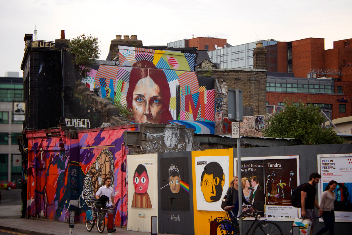 Group of People Walking Beside the Wall